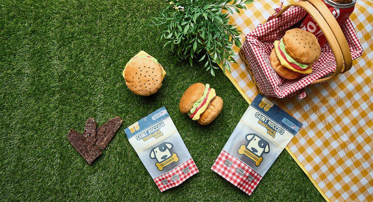 Saint Rocco's Treats featured on grass and picnic blanket with dog toys.